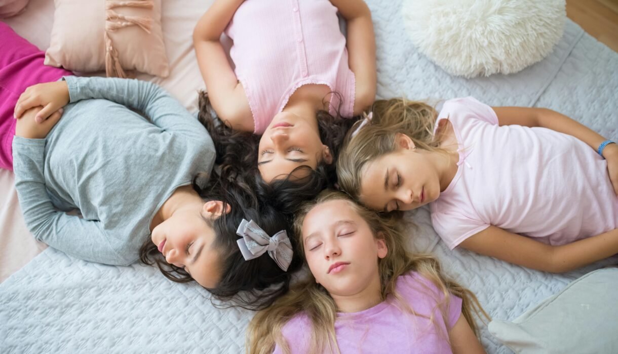 Four young girls peacefully sleeping during a fun sleepover.