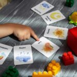 Inicio Close-up of a child pointing at colorful educational flashcards and toys, promoting learning and creativity.