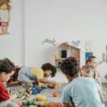 A lively group of children playing inside a colorful kindergarten classroom.